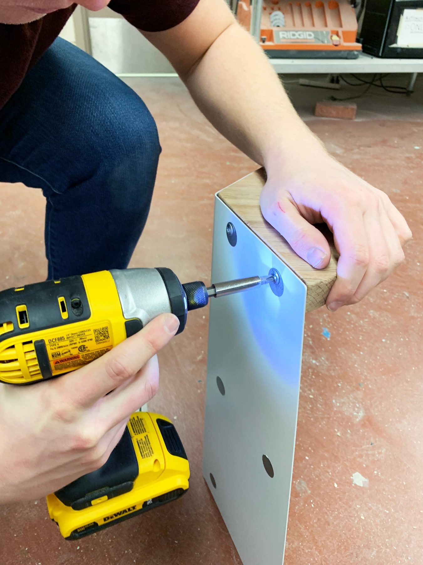 Driving screws through the sheet metal into the oak seat
