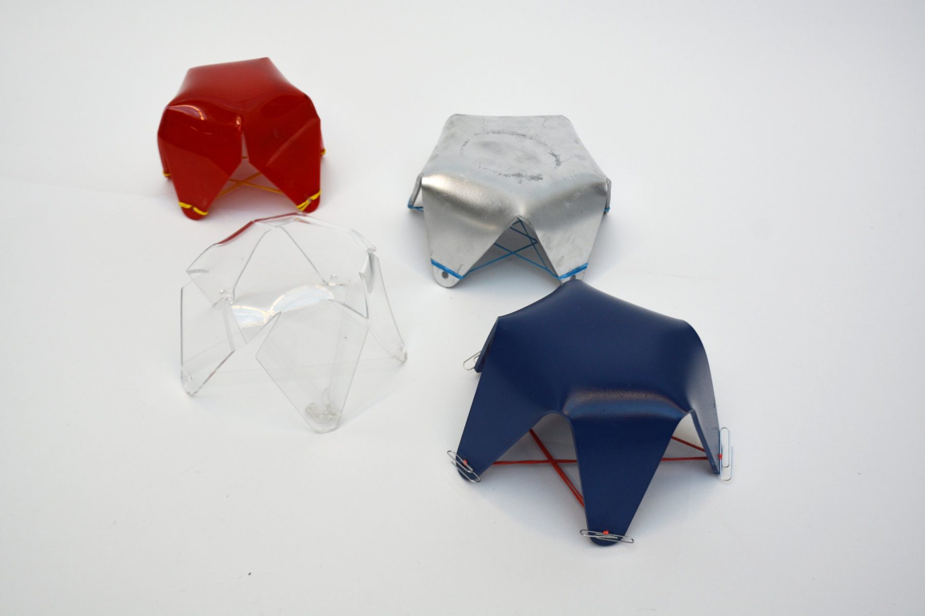 Folded sheet models in red, clear, aluminum and blue