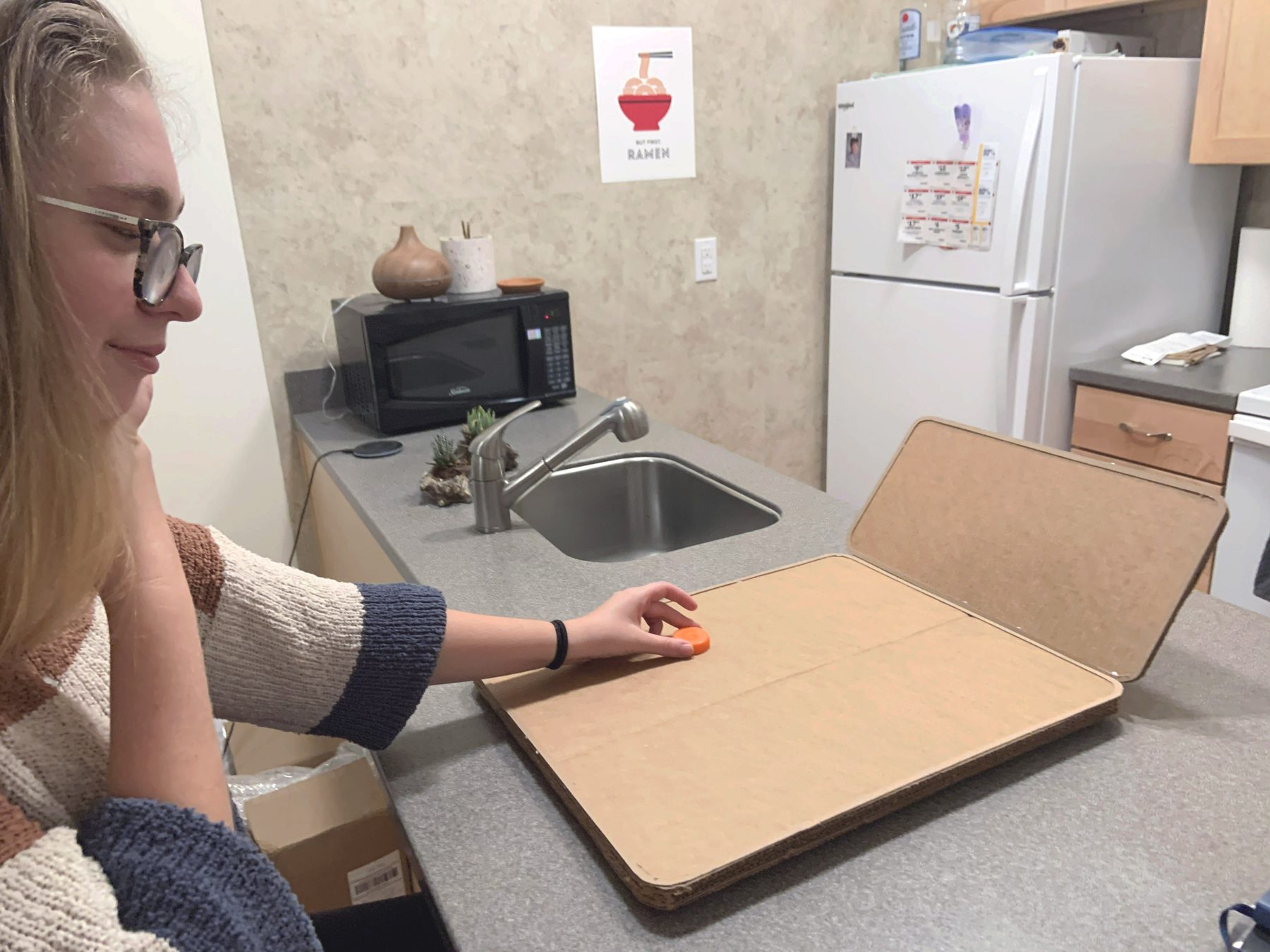 Testing reach with a full-scale cardboard mockup at a kitchen counter