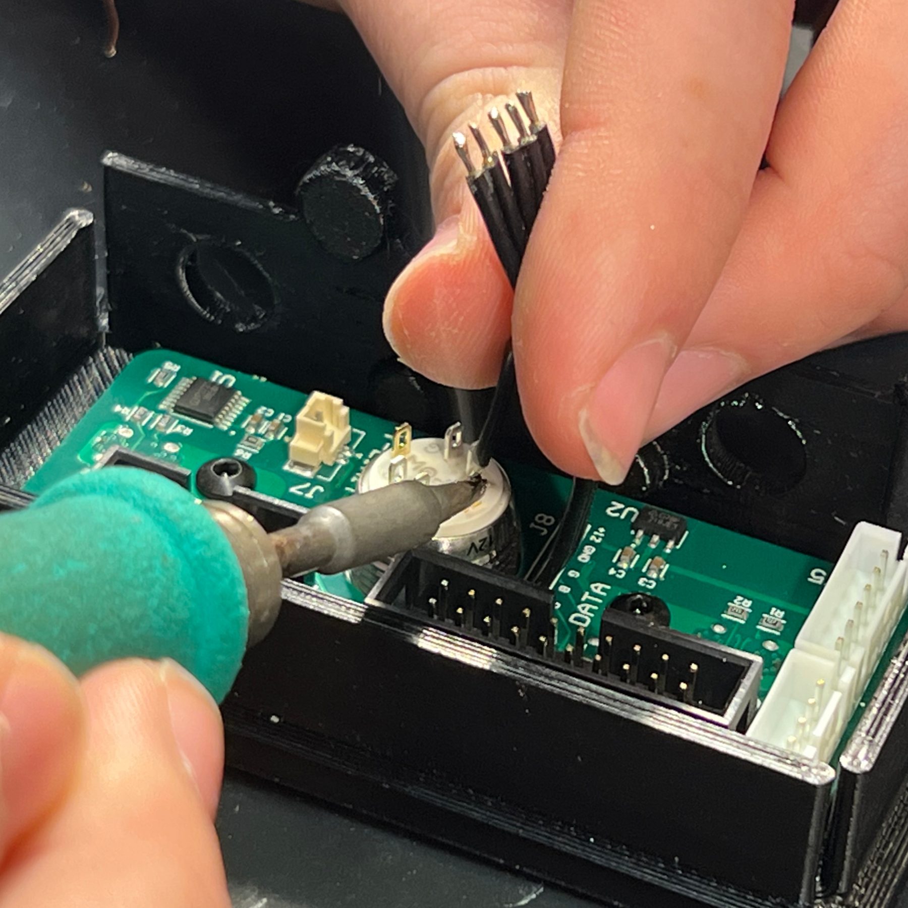 Soldering ribbon cable to the power button.