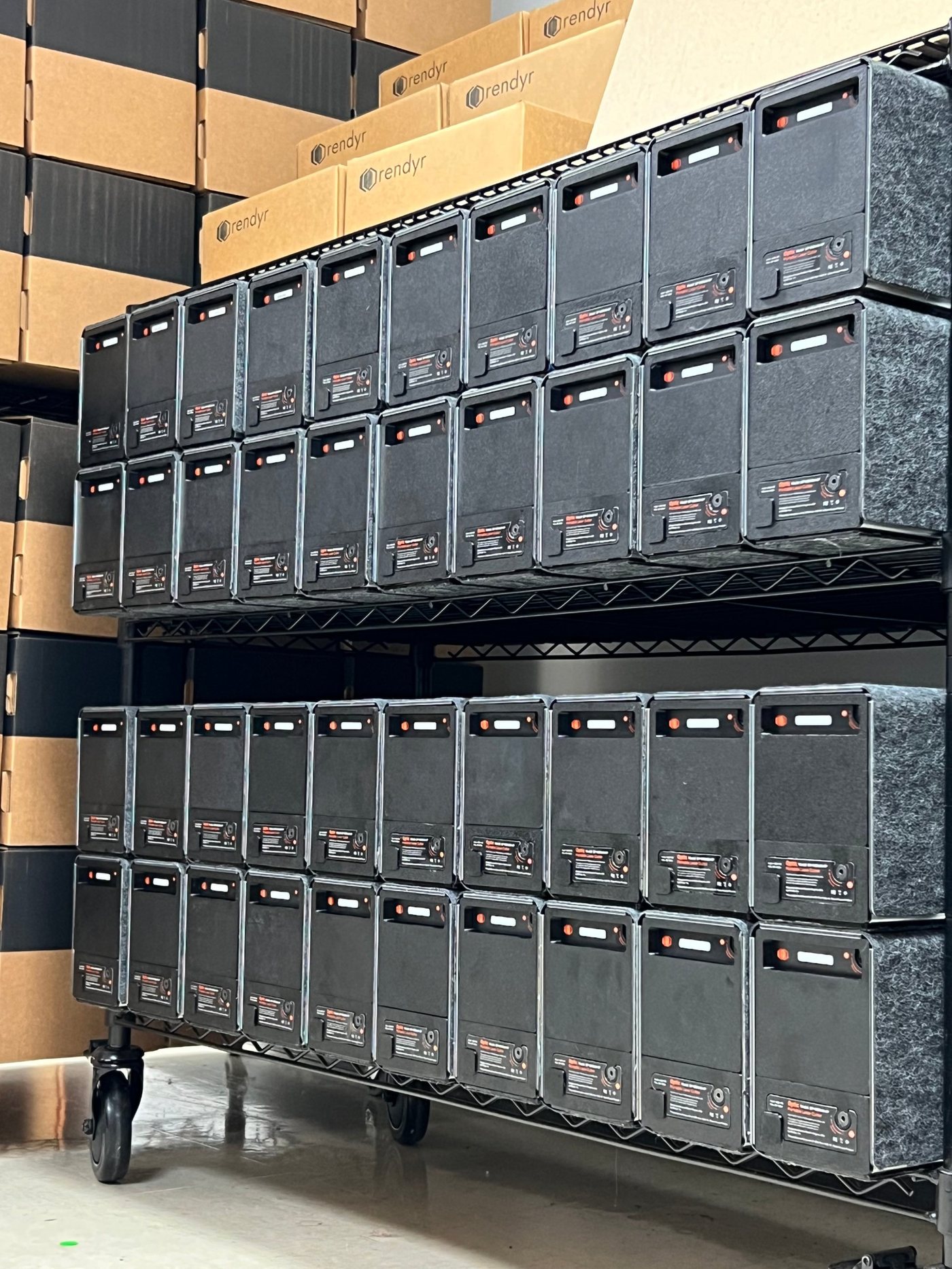 Two shelves of packed-up Optics tested and ready to ship, with branded boxes stacked behind